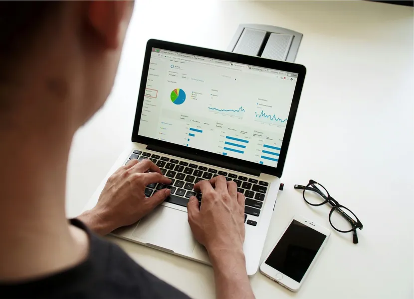 Hands on a laptop showing a dashboard